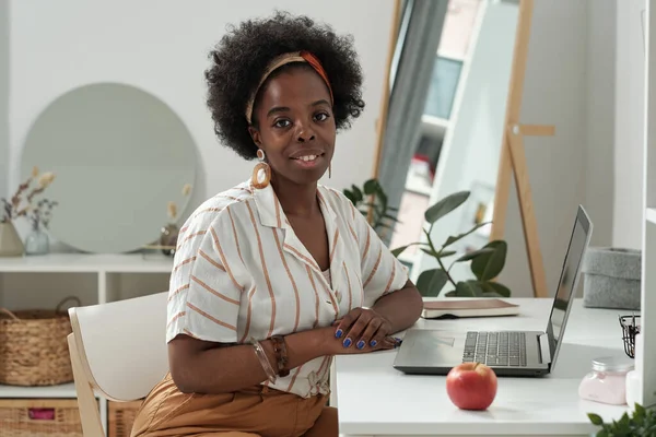 Ung framgångsrik kvinna sitter vid skrivbordet framför laptop — Stockfoto