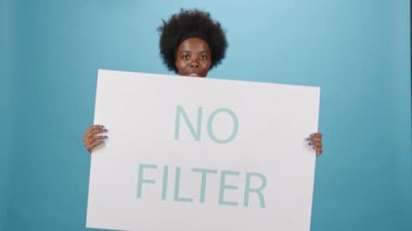 İç çamaşırlı, Afro-Amerikan bir kadının orta boy portresi. Elinde sağlıklı, kıvrımlı vücudunun mavi arka planda durduğunu gösteren bir poster var.