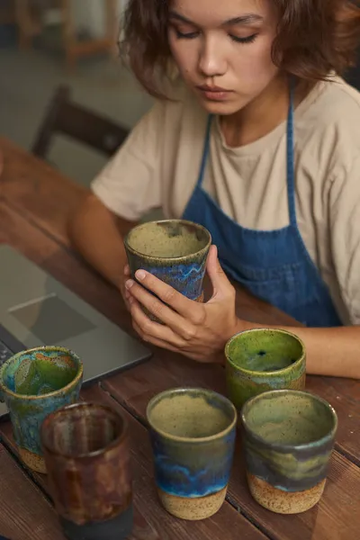 Mujer examinando tazas hechas a mano antes de enviar comprador — Foto de Stock