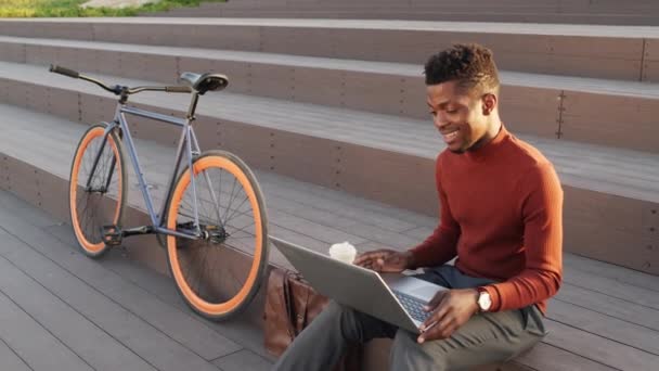 Zekice Giyinmiş Arkadaşı Arkadaşıyla Bilgisayarında Görüntülü Konuşma Yapan Merdivenlerde Bisikletinin — Stok video