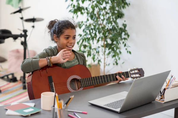 Felice preteen studentessa agitando mano al suo insegnante durante la lezione online — Foto Stock