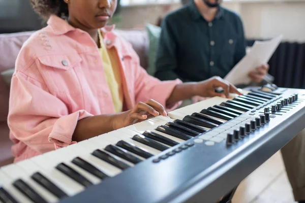 Mãos de estudante diligente biracial tocando teclado de piano — Fotografia de Stock