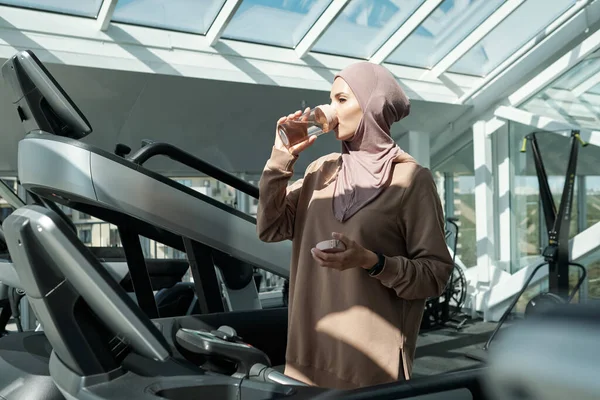 Jonge moslim vrouw met water na harde training — Stockfoto