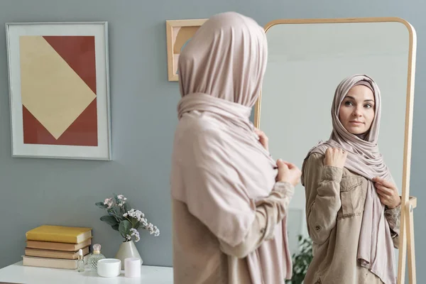 Mujer musulmana joven en hijab mirando en el espejo —  Fotos de Stock