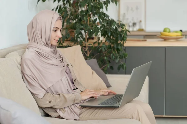 Mladá seriózní podnikatelka v hidžábu sítí doma — Stock fotografie