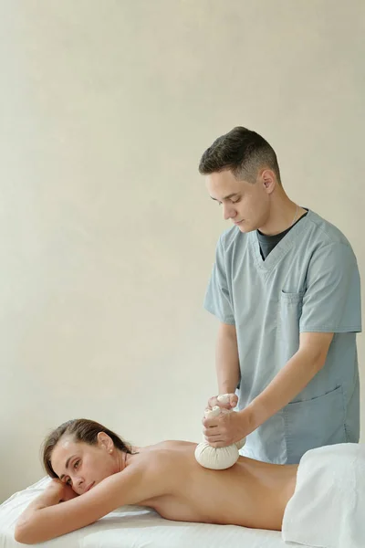 Jeune client de salon de spa profitant d'un massage thaï — Photo