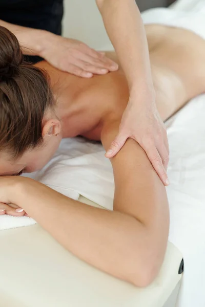 Hände des Massagetherapeuten massieren die oberen Teile der weiblichen Arme — Stockfoto