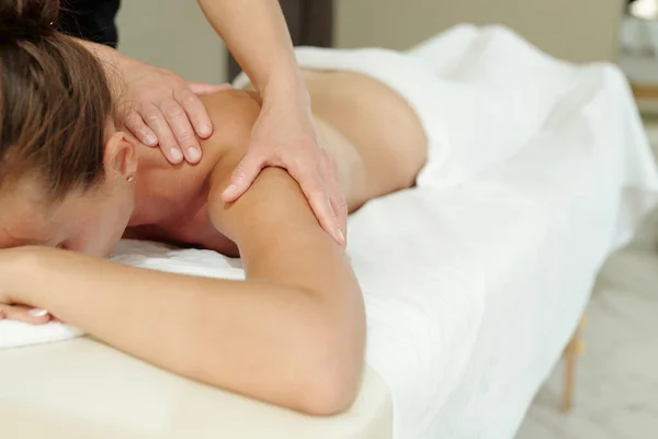 Jeune femme détendue allongée sur une table de massage pendant la procédure de soins du corps — Photo