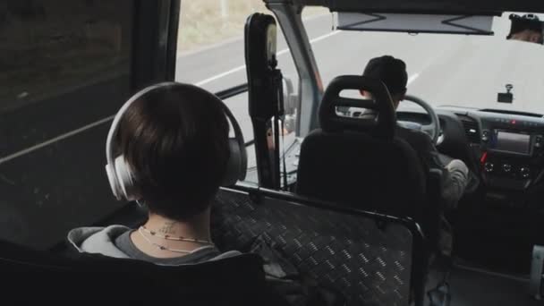 乘坐公共汽车时 坐在司机后面看着车窗的脖子上有纹身的短发少女的后视镜中等特写 — 图库视频影像