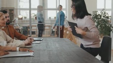 Asyalı kadının masaya oturduğu ve iş görüşmesinin başında üç İK temsilcisine başvuru formunu teslim ettiği görüntüler.