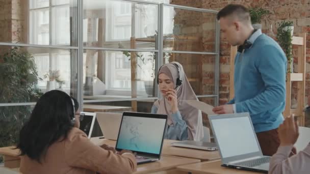 Pan Кадры Менеджер Колл Центра Разговаривает Мусульманкой Работницей Наушниках Отвечает — стоковое видео