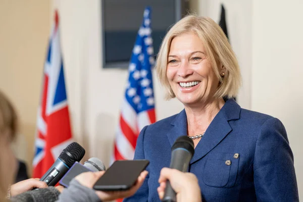Sonriente mujer política hablando con la prensa — Foto de Stock