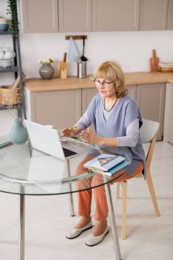 Görüntülü konuşmayla iletişim kuran kendinden emin olgun bir kadın.