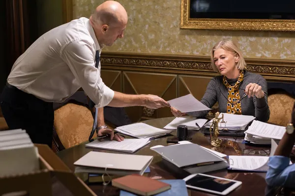 Kale zakenman doorgeven van papier aan zijn volwassen vrouwelijke collega — Stockfoto