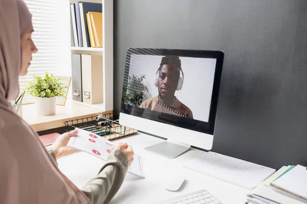 Joven estudiante africano en auriculares en la pantalla del ordenador escuchando al profesor —  Fotos de Stock