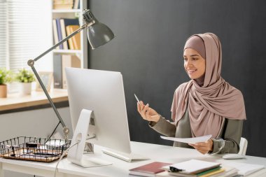 Mutlu genç Müslüman kadın çevrimiçi ders alıyor