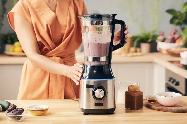 Mão de mulher jovem que prepara o batido no liquidificador — Fotografia de Stock