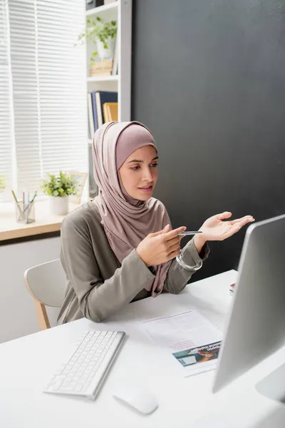 Joven profesor confiado en hijab hablando a la audiencia en línea —  Fotos de Stock