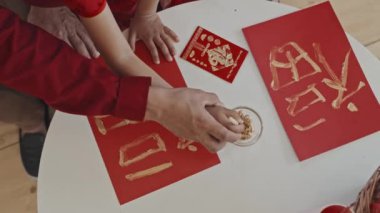 Küçük kızının Çin 'e yeni yıl kartı yapmasına yardım eden tanınmayan bir babanın el kamerasıyla çekilmiş resmi.