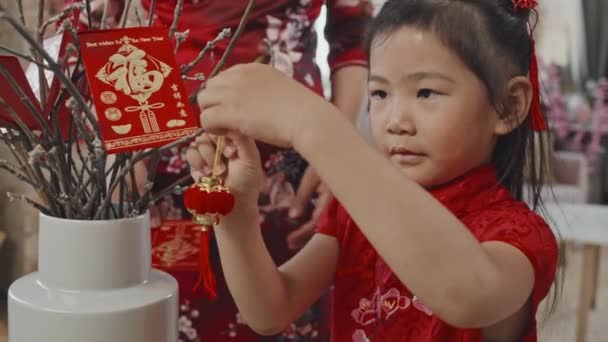 Close Slowmo Van Schattig Chinees Meisje Rood Traditionele Jurk Zetten — Stockvideo