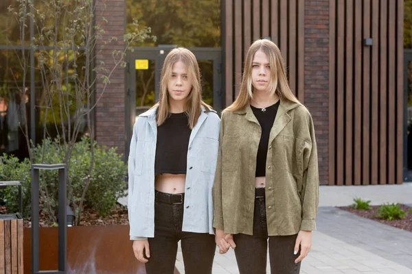 Serios gemelos adolescentes en ropa de casualstand contra la construcción —  Fotos de Stock