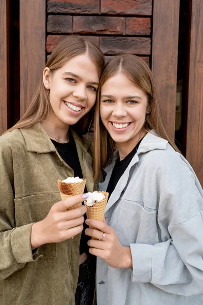 Schöne Zwillingsschwestern mit langen blonden Haaren mit Eis — Stockfoto