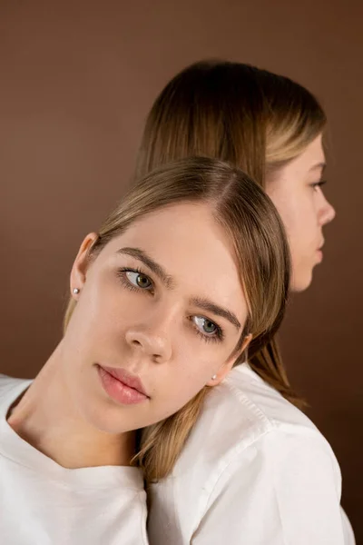 Ung vacker kvinna lutar sig mot axeln på sin tvillingsyster — Stockfoto