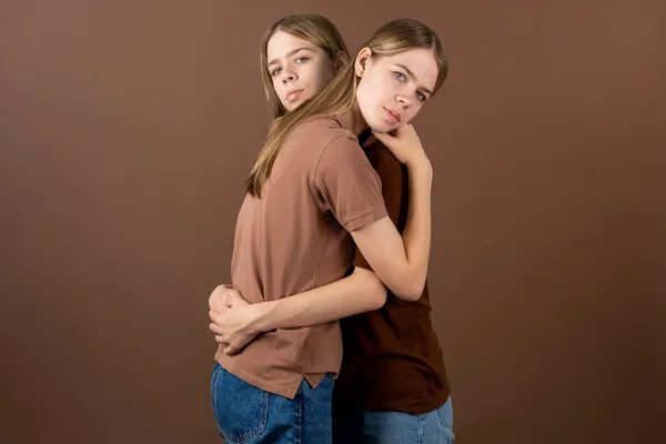 Roztomilé dospívající dvojčata dávat navzájem objetí před kamerou — Stock fotografie