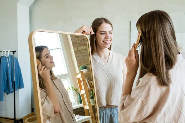 Heureux adolescent jumeaux debout par grand miroir et bavarder — Photo