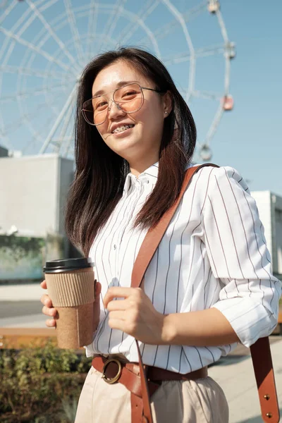 Щаслива молода жінка зі склянкою кави насолоджується перервою — стокове фото