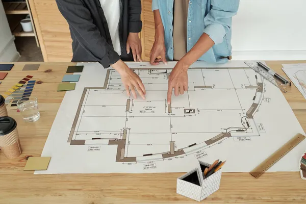 Två unga arkitekters händer pekar på skiss på bordet — Stockfoto