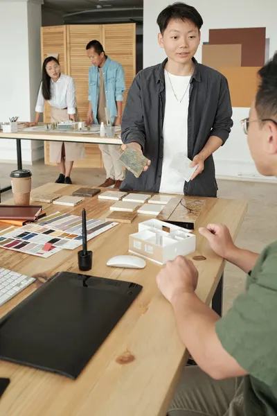 Joven empresaria mostrando muestras de compuestos interiores a su colega masculino — Foto de Stock