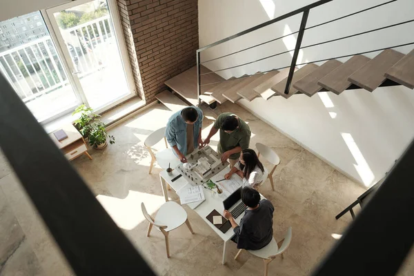 Cuatro jóvenes arquitectos chinos discutiendo el diseño de la casa — Foto de Stock