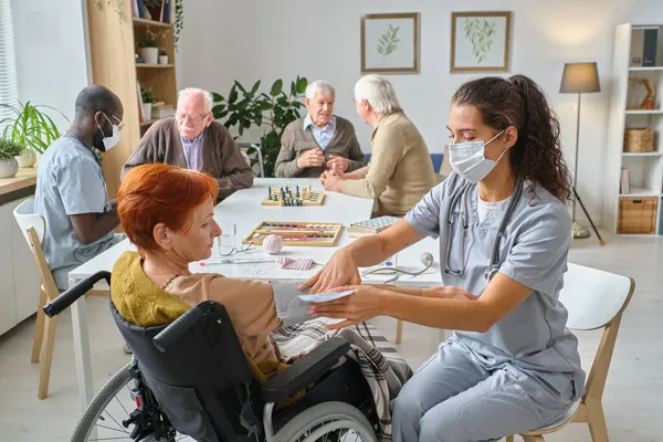 Sjuksköterska mäter trycket på äldre personer — Stockfoto