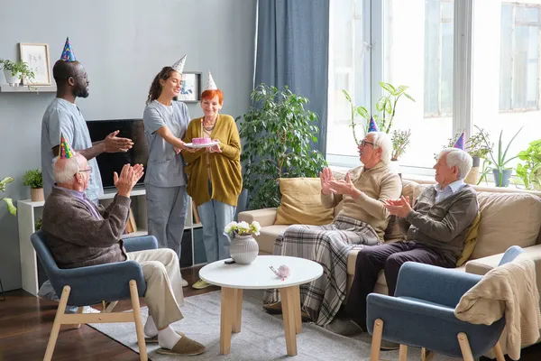 Personas mayores con enfermera celebrando cumpleaños — Foto de Stock
