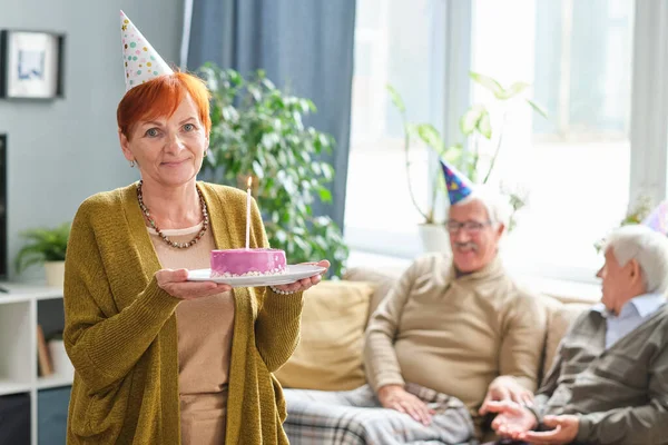 Mujer mayor sosteniendo pastel de cumpleaños — Foto de Stock