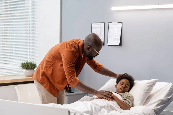 Far bryr sig om sin son på sjukhuset — Stockfoto