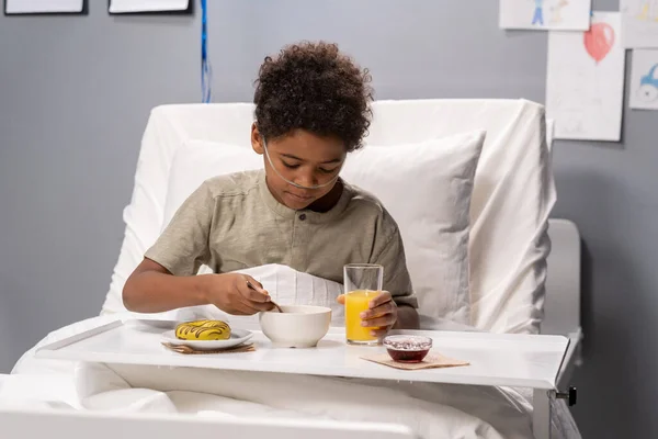 Menino tomando café da manhã na enfermaria — Fotografia de Stock