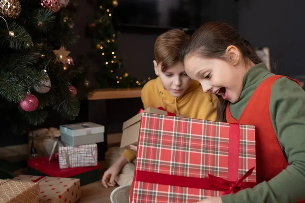 Aufgeregtes Mädchen eröffnet Weihnachtsgeschenk — Stockfoto