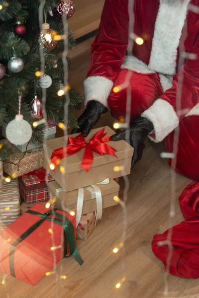 Weihnachtsmann stiehlt Geschenk unter Baum — Stockfoto