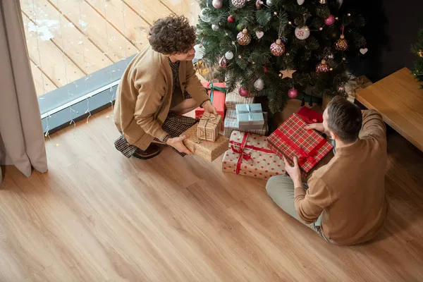 Coppia mettendo i regali sotto l'albero di Natale — Foto Stock