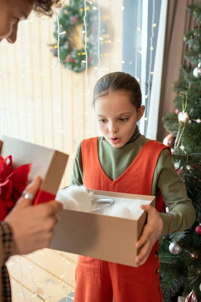 Überraschtes Mädchen schaut auf Geschenk — Stockfoto