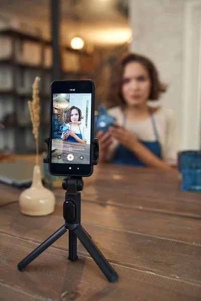 Smartphone en trípode con joven artesana en pantalla — Foto de Stock