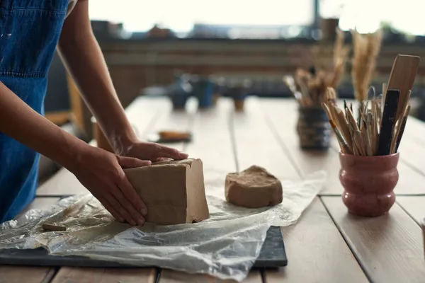 Mãos de artesão segurando grande pedaço de argila durante o trabalho — Fotografia de Stock