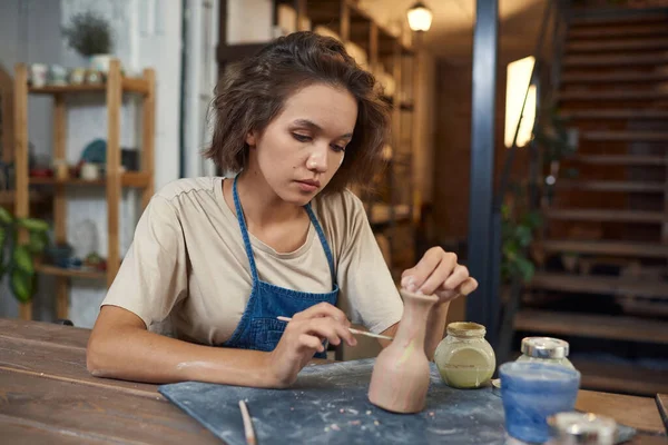 Junge Kunsthandwerkerin in Arbeitskleidung mit Pinsel und Krug — Stockfoto