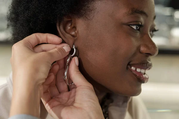 Glückliche junge Afrikanerin probiert neue Ohrringe an — Stockfoto