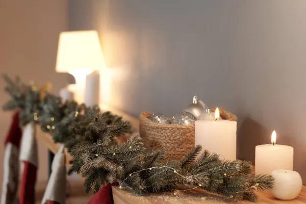 Row of white burning candles and decorative coniferous branches — Stock Photo, Image