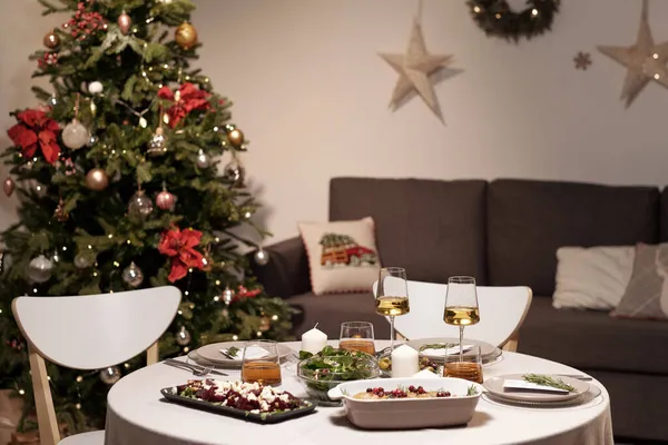 装飾された木を背景に夕食のために提供される丸いテーブル — ストック写真