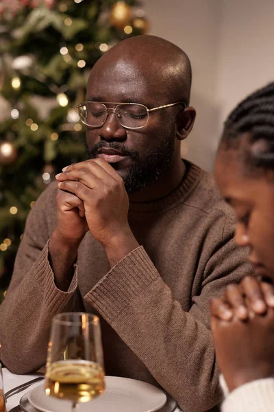 Jonge Afrikaanse man in bril en zijn vrouw bidden samen — Stockfoto