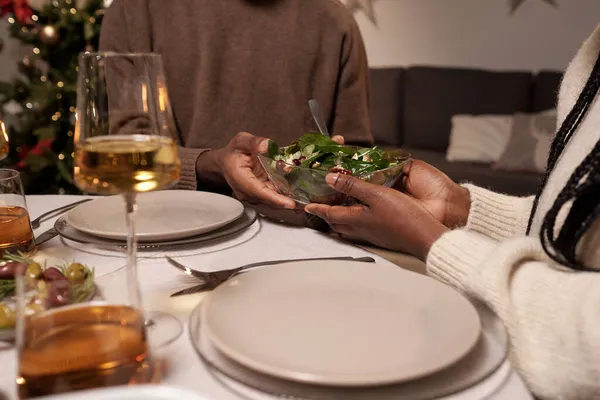 Hands of young African couple holding bowl with salad — Stock Photo, Image